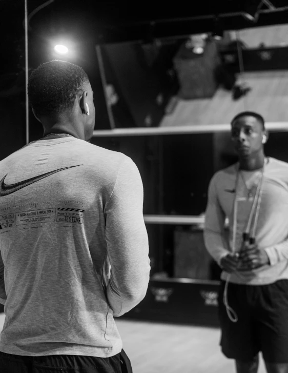 a couple of men standing next to each other, a black and white photo, by Marshall Arisman, pexels contest winner, in a gym, jaylen brown, full of reflections, profile image