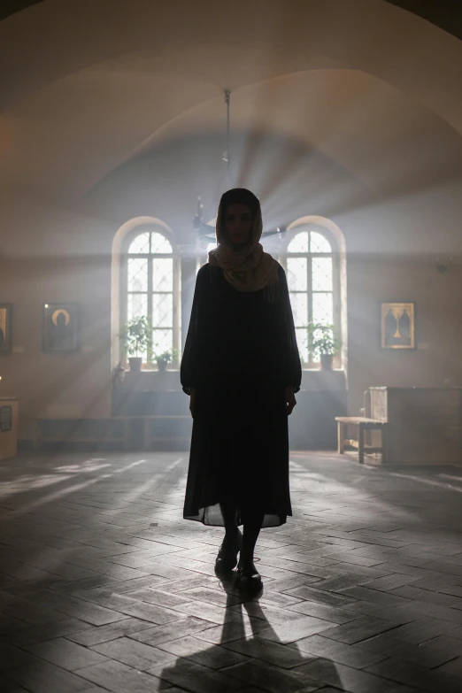 a woman standing in a dimly lit room, symbolism, in orthodox church, production still, hammershøi, promotional image