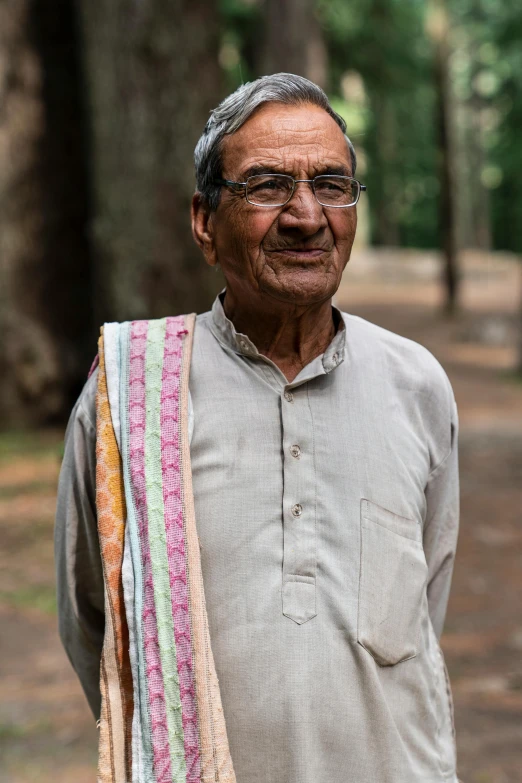 a man standing in the middle of a forest, bengal school of art, tight wrinkled cloath, profile image, elderly, smiling