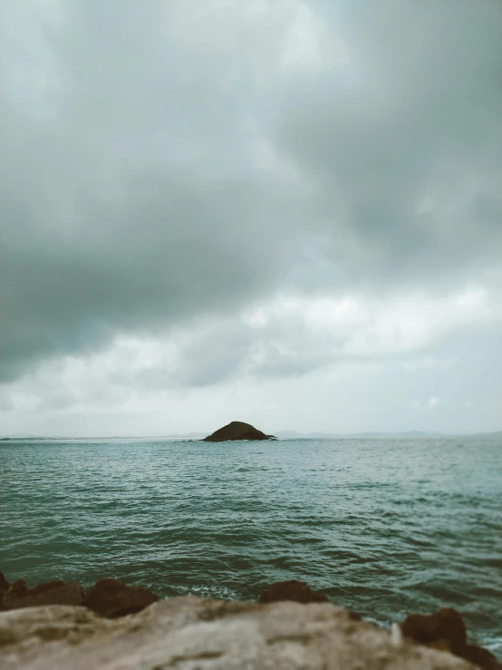 a small island in the middle of the ocean, by Pablo Rey, unsplash, romanticism, overcast gray skies, lomography photo, 'silent hill ', photo taken on fujifilm superia