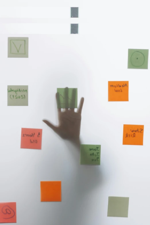 a person standing in front of a whiteboard covered in post it notes, a hologram, hand with five fingers, on a gray background, square, thumbnail