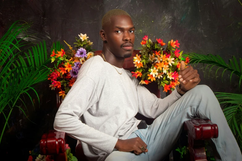 a man sitting in a chair holding a bunch of flowers, an album cover, inspired by David Bailly, pexels contest winner, adut akech, attractive young man, shot in the photo studio, lush flora