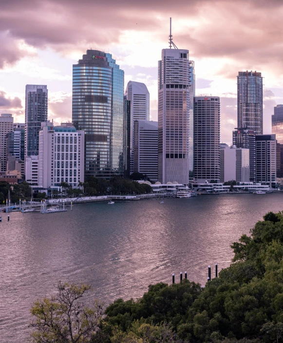 a large body of water with a city in the background, by Anna Findlay, pexels contest winner, oz series, pink marble building, outram, city buildings on top of trees