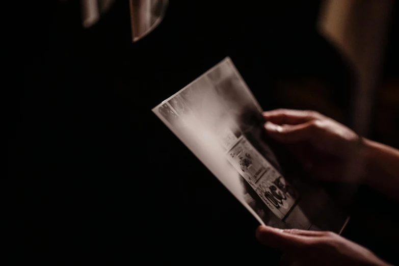 a person reading a book in the dark, an etching, pexels contest winner, holography, faked ticket close up, film artifacts, close up shot from the side, holding a drink
