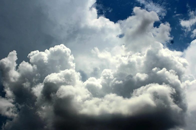 a plane flying through a cloudy blue sky, by Jan Rustem, unsplash, romanticism, towering cumulonimbus clouds, hyperdetailed storm clouds, “puffy cloudscape, nature photo