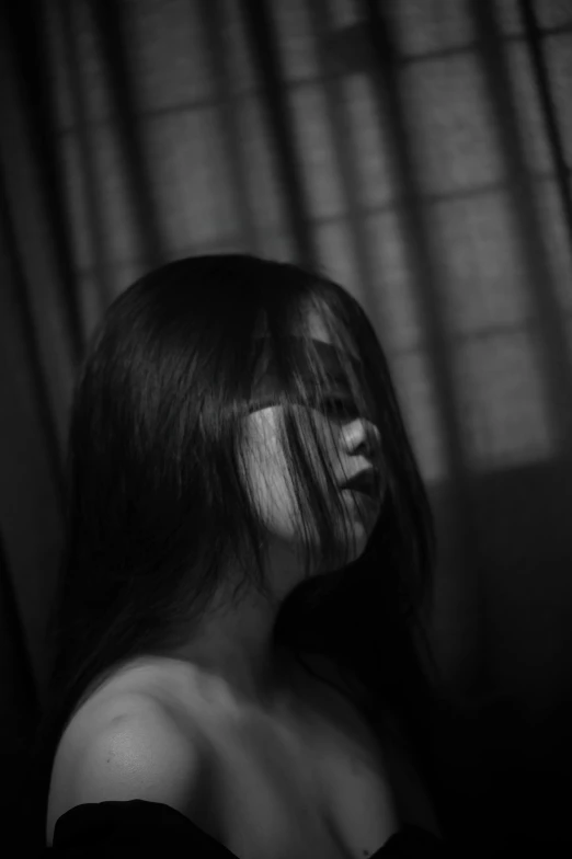 a woman with long hair standing in front of a window, a black and white photo, inspired by Yu Zhiding, unsplash, with a bruised face and bruises, song nan li, faceless, asian female