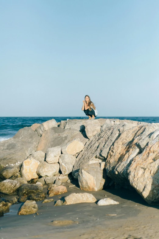 a woman sitting on a rock on the beach, by Niko Henrichon, minimalism, in barcelona, medium format. soft light, 15081959 21121991 01012000 4k, panoramic view of girl