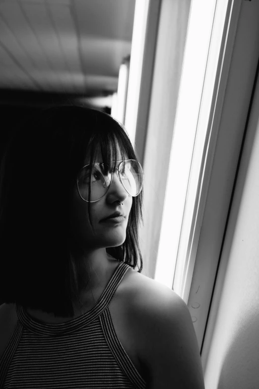 a black and white photo of a woman looking out a window, inspired by Ayami Kojima, curtain bangs, with sunglass, brandon woelfel, ((portrait))