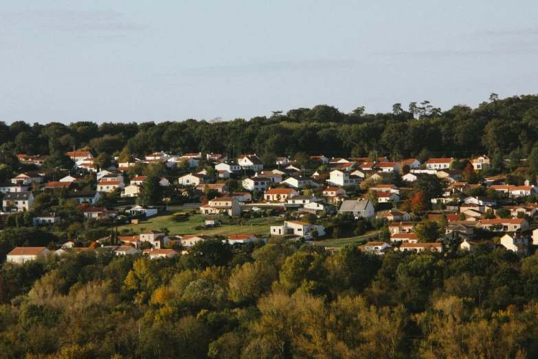 a group of houses sitting on top of a lush green hillside, bocage, during autumn, white buildings with red roofs, early 2 0 0 0 s