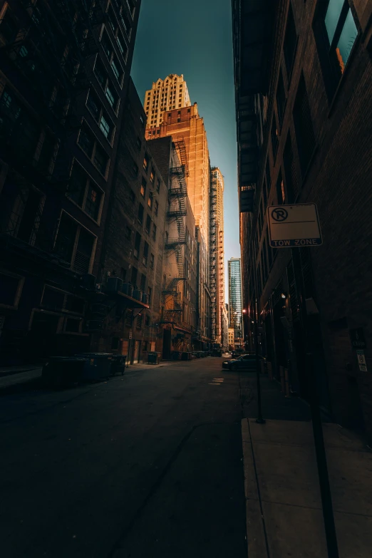 a city street with tall buildings in the background, by Andrew Domachowski, unsplash contest winner, location [ chicago ( alley ) ], filtered evening light, abandoned city, maze of streets