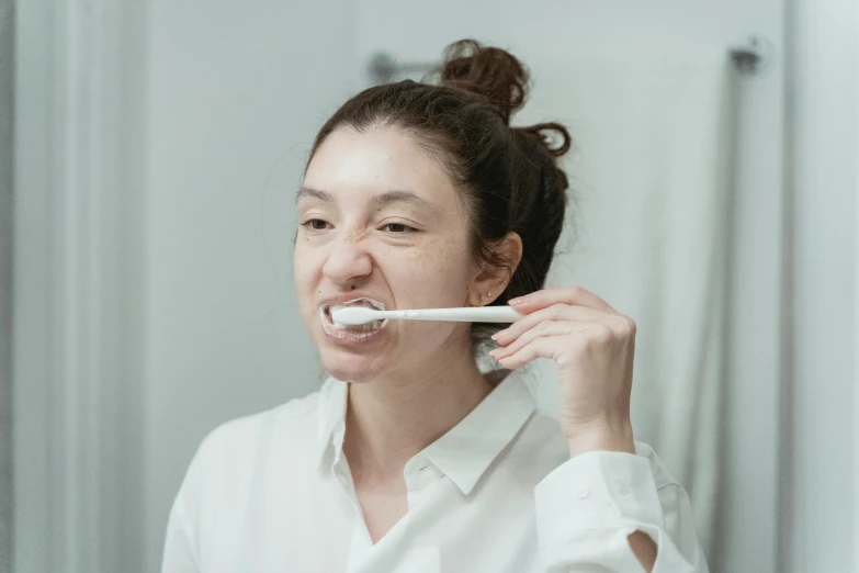 a woman brushing her teeth in front of a mirror, by Nicolette Macnamara, happening, soft volume absorbation, manly, uniform teeth, profile image