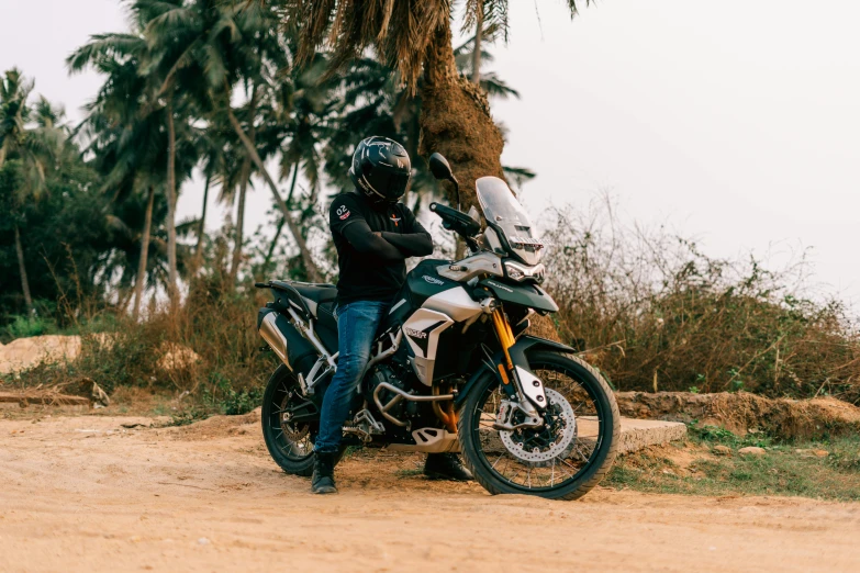 a person sitting on a motorcycle on a dirt road, pexels contest winner, triumph, india, with a sleek spoiler, avatar image