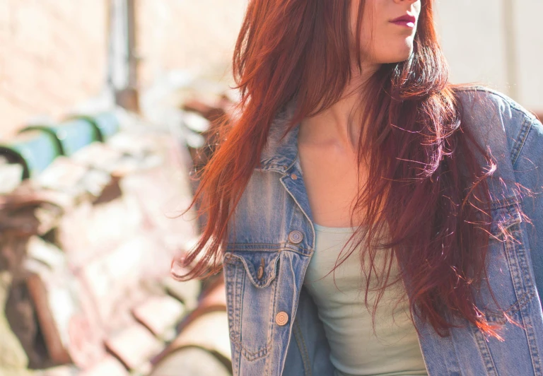 a woman with red hair wearing a denim jacket, trending on pexels, tinted colours, long hair and red shirt, loosely cropped, wearing gorgeous clothing