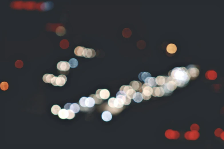 a street filled with lots of traffic at night, unsplash, generative art, overcast bokeh - c 5, sparkles, bokeh”