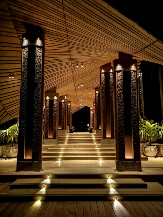 the inside of a building lit up at night, bali, catwalks, volumetric outdoor lighting, adorned pillars