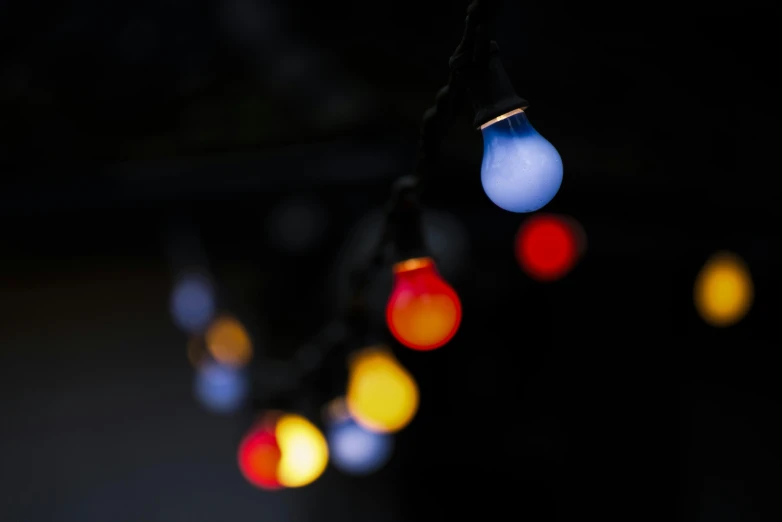 a string of christmas lights in the dark, inspired by Elsa Bleda, bauhaus, multicoloured, outdoor lighting, multi colour