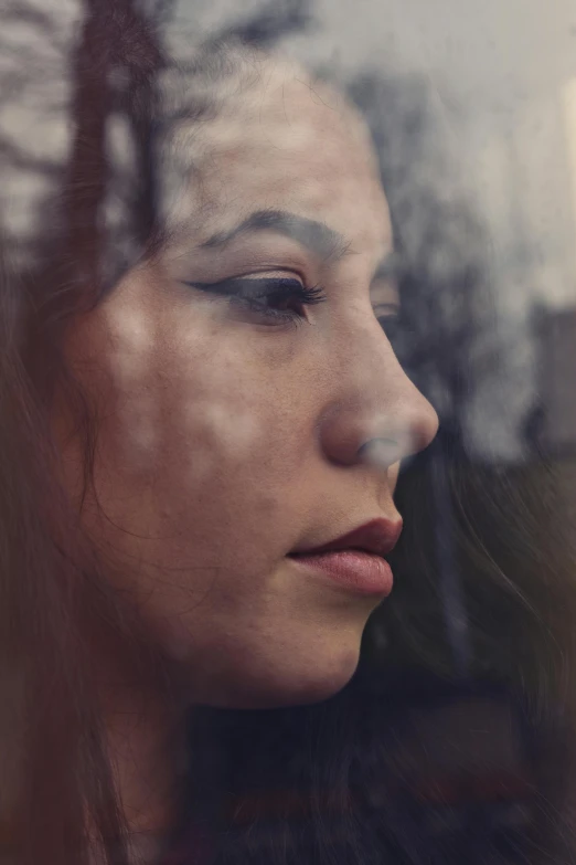 a close up of a person looking out a window, her gaze is downcast, face scars, profile face, photo of young woman