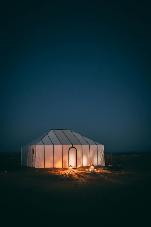 a white tent sitting in the middle of a desert, lit windows, sustainable architecture, nightime, profile image