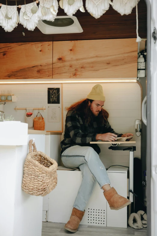 a woman sitting at a table working on a laptop, by Jessie Algie, tiny house, sink, trending on vsco, vehicle