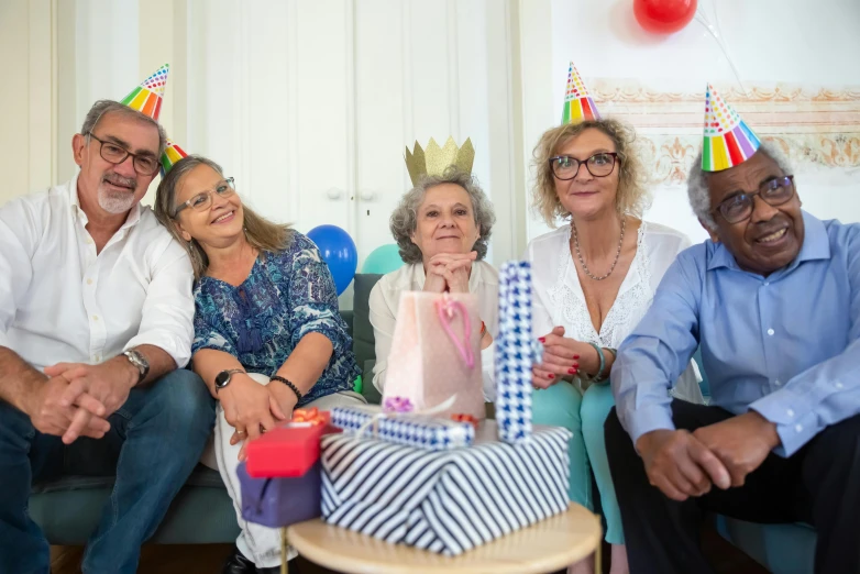 a group of people sitting on top of a couch, a portrait, by Jan Tengnagel, pexels contest winner, celebrating a birthday, aged, ahestetic, where a large