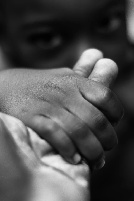 a close up of a person holding a child's hand, a black and white photo, by Dan Christensen, african american, 15081959 21121991 01012000 4k, compassion, play of light