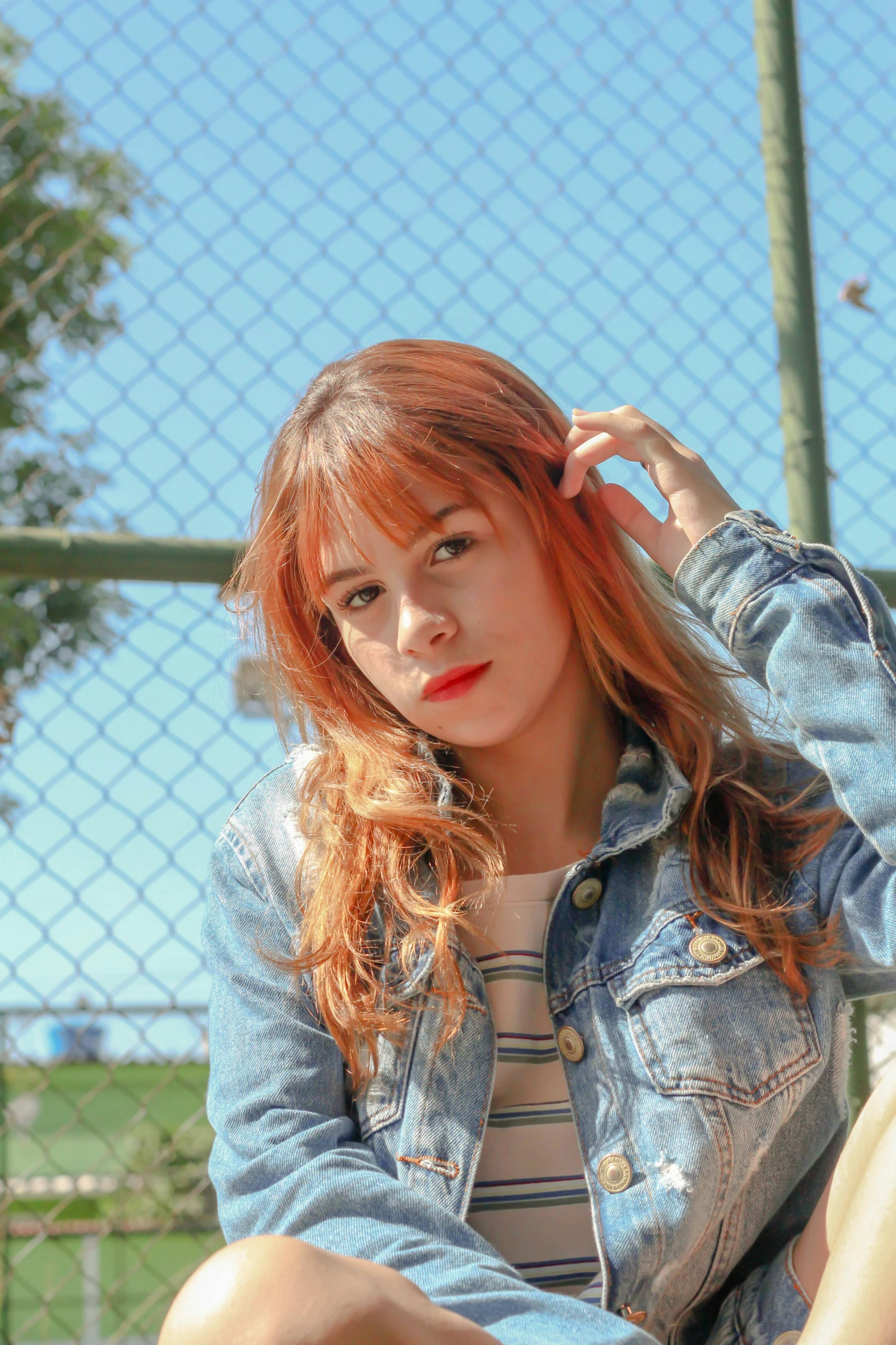 a woman sitting on top of a tennis court holding a racquet, an album cover, by Alejandro Obregón, pexels contest winner, brown-red-hair pretty face, wearing a jeans jackets, whitebangs, headshot profile picture