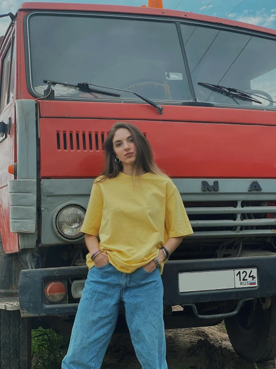 a woman standing in front of a red truck, by Attila Meszlenyi, wearing a modern yellow tshirt, 90s photo, background image, dasha taran