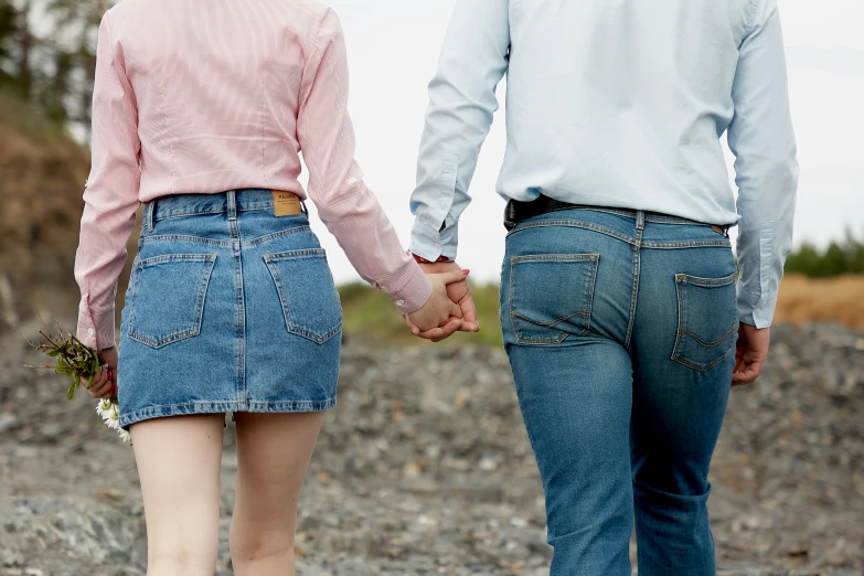 a man and a woman walking down a gravel road, an album cover, by Julia Pishtar, pexels, blue jeans, thigh gap, lesbians, blue and pink
