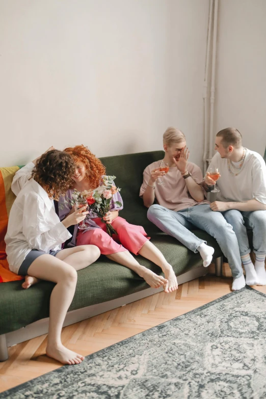 a group of people sitting on top of a green couch, pexels contest winner, incoherents, drinking their hearts out, sitting with flowers, lesbian, location in a apartment