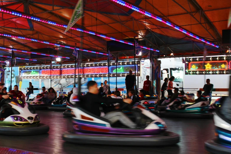 a group of people riding bumper cars inside of a building