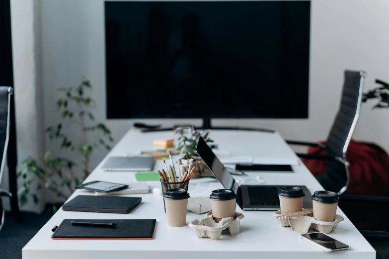 a desktop computer sitting on top of a white desk, trending on unsplash, private press, group sit at table, 9 9 designs, miscellaneous objects, table in front with a cup