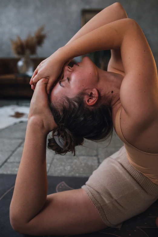 a woman is doing a yoga pose on the floor, by Matija Jama, pexels contest winner, renaissance, greeting hand on head, focused on neck, outside, sweat