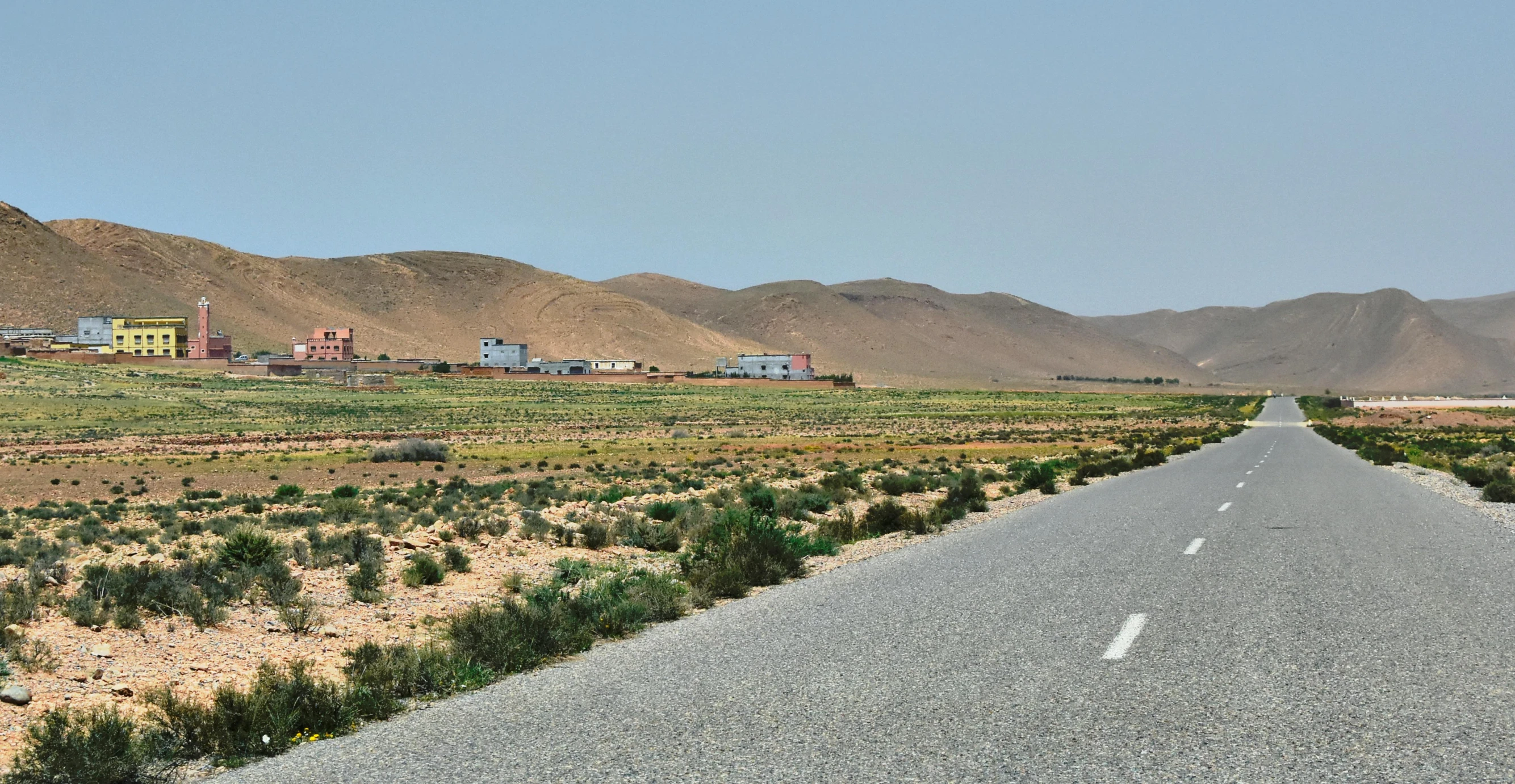 a road in the middle of a desert with mountains in the background, les nabis, white houses, campsites, studio ghilbi, farms