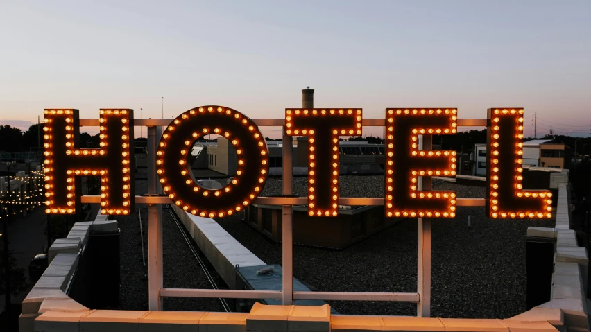 a hotel sign sitting on top of a roof, by Carey Morris, unsplash contest winner, graffiti, skin made of led point lights, nixie tubes, hoyte van hoytema, 5 feet away