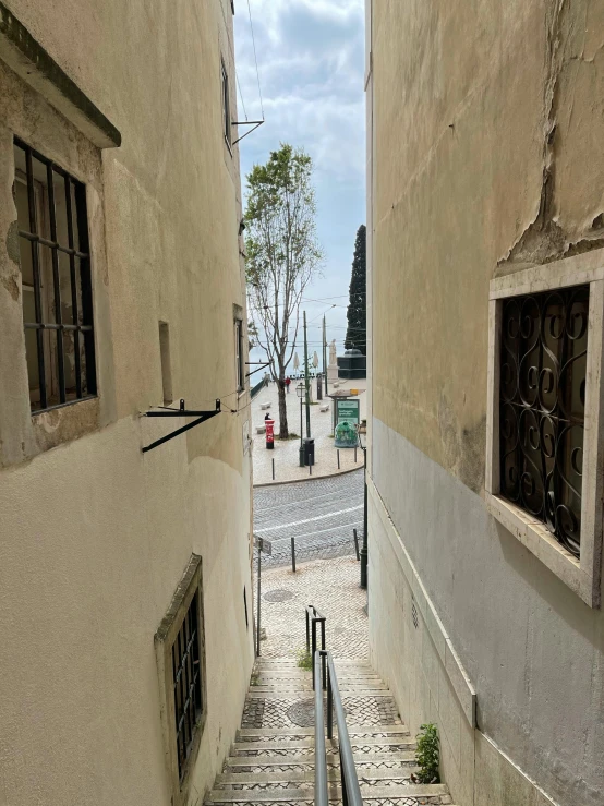 a set of stairs going up the side of a building, by Tom Wänerstrand, pexels contest winner, street art, the city of lisbon, view out of a window, stone grotto in the center, youtube thumbnail