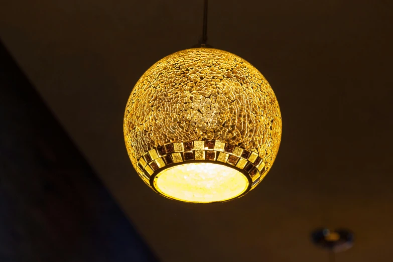 a close up of a light hanging from a ceiling, by Julia Pishtar, unsplash, arabesque, gold dappled lighting, table light, retro stylised, photorealistic lighting