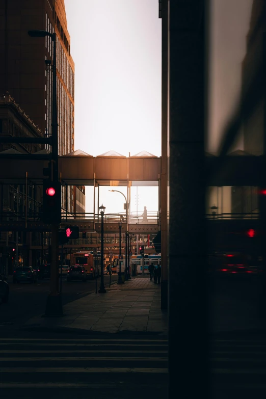 a street filled with lots of traffic next to tall buildings, a picture, unsplash contest winner, dramatic backlight, looking through a window frame, minneapolis, instagram photo