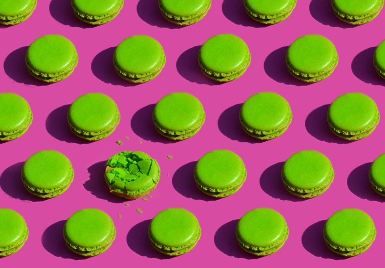 a group of green macarons sitting on top of a pink surface, by Julia Pishtar, pop art, andres gursky, edible crypto, pattern, epicurious