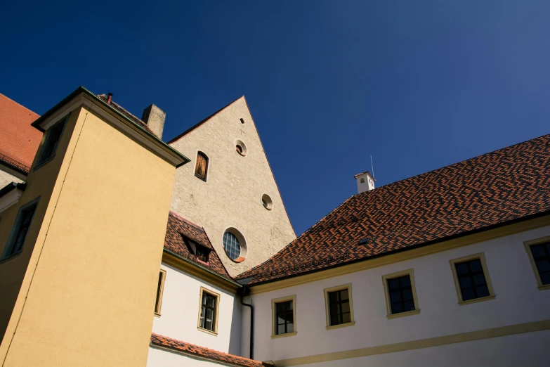 a couple of buildings that are next to each other, unsplash, danube school, in a monestry natural lighting, ochre, museum photo, low-angle
