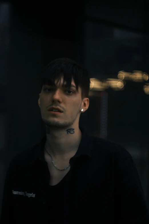 a man in a black shirt standing in a dark room, an album cover, inspired by Elsa Bleda, unsplash contest winner, realism, lil peep, standing in a city street, androgynous face, headshot photo