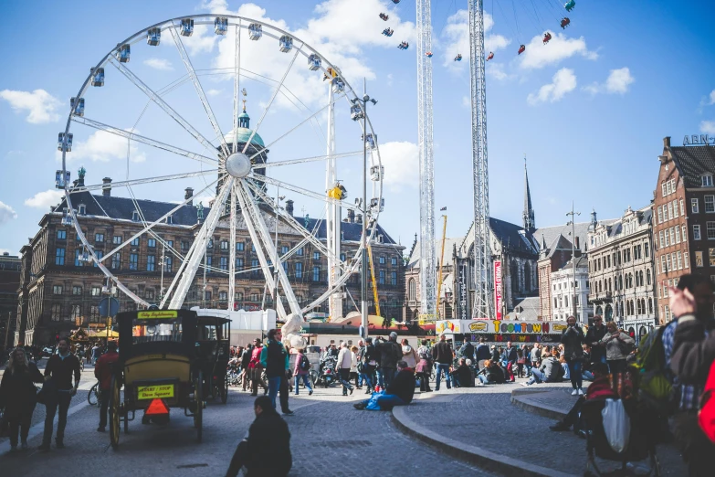 a large ferris wheel sitting in the middle of a city, a photo, by Jan Tengnagel, pexels contest winner, happening, people walking around, marketsquare, 🚿🗝📝, festival vibes