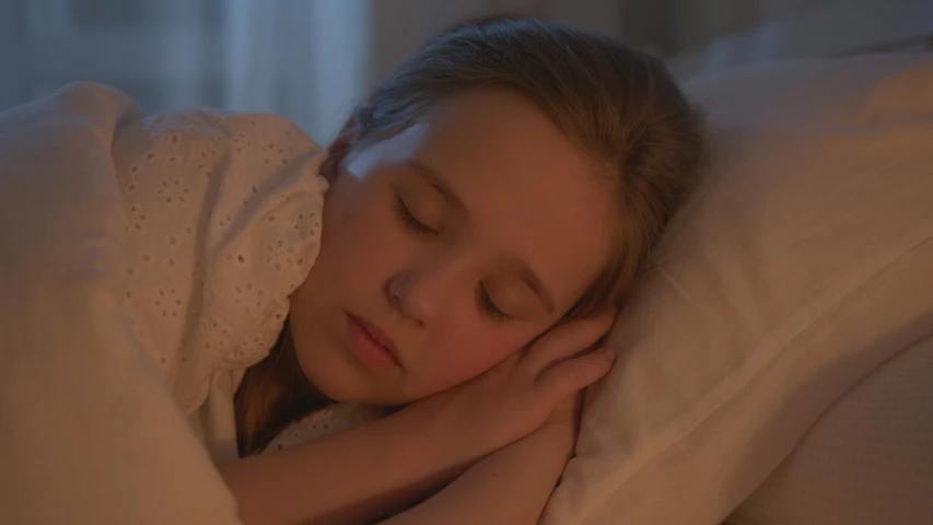 a little girl laying in bed with her eyes closed, inspired by Sophie Anderson, pexels contest winner, realism, still from stranger things, soft lighting 8 k resolution, calm night. over shoulder shot, movie still 8 k