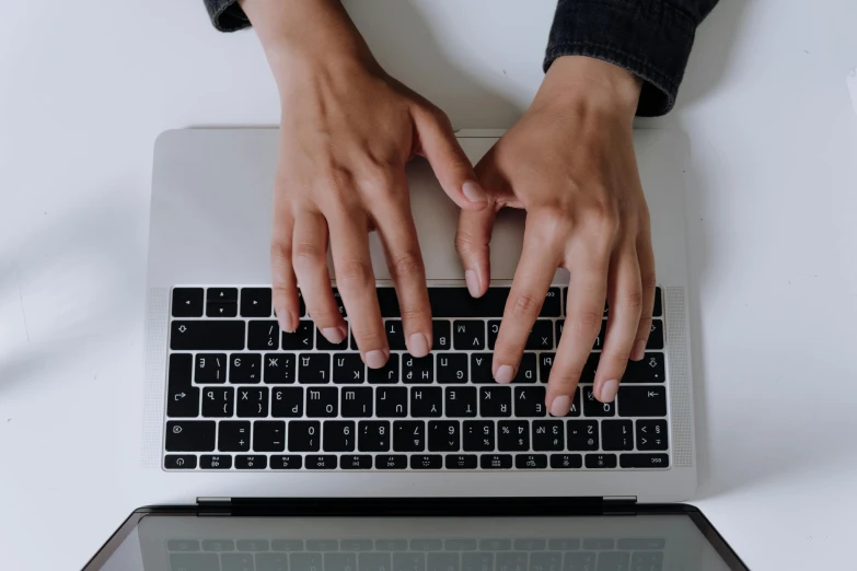 a close up of a person typing on a laptop, by Carey Morris, pexels, high angle shot, naturalistic technique, multiple stories, background image