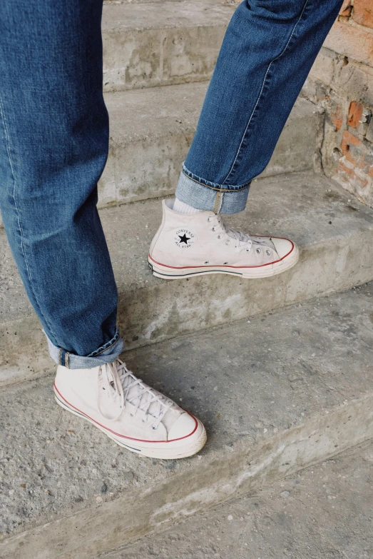 a person standing on a set of stairs, trending on pexels, renaissance, converse, wearing denim, soft white rubber, 70s photo