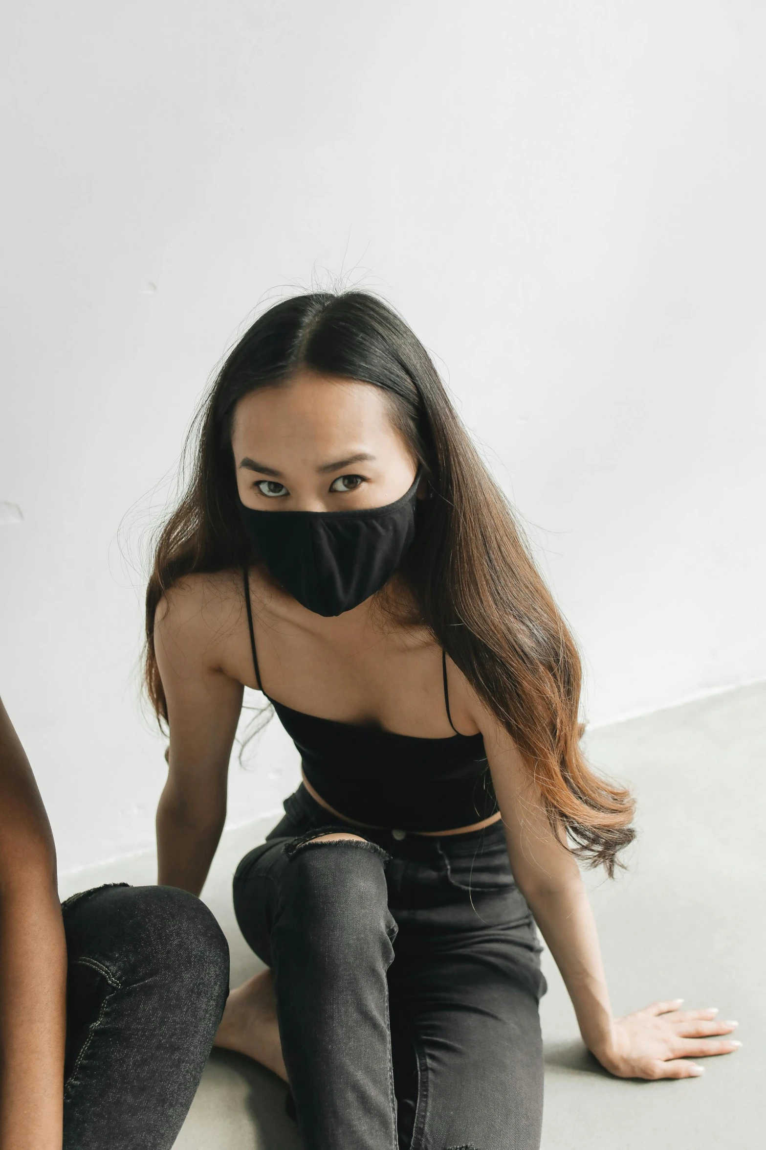 a woman sitting on the floor wearing a face mask, wearing a cropped black tank top, asian features, with a covered face, longque chen