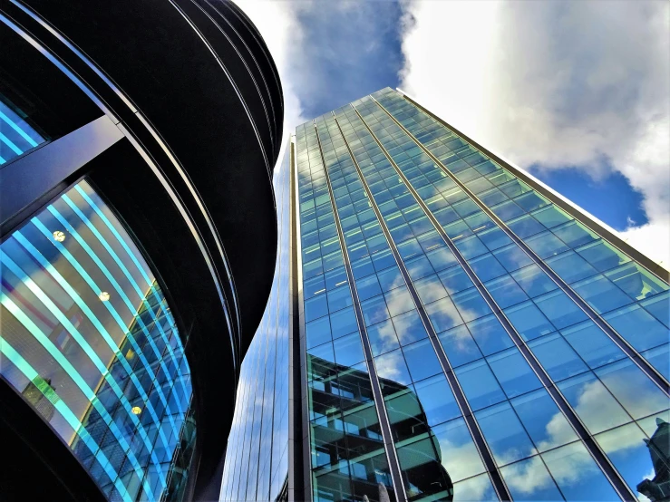 a couple of tall buildings next to each other, by David Donaldson, pexels contest winner, glass and metal : : peugot onyx, blue sky, instagram picture, contrasting colours