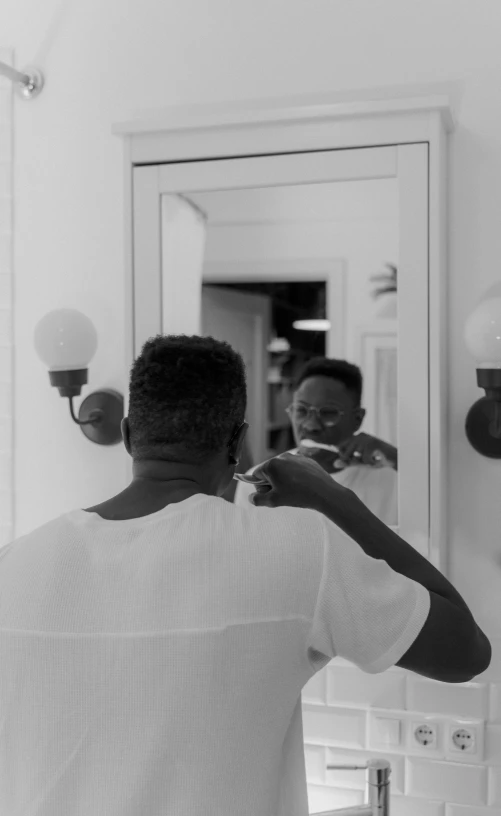 a man standing in front of a mirror brushing his teeth, by Matija Jama, pexels contest winner, afroamerican, low quality footage, back to back, flat top haircut