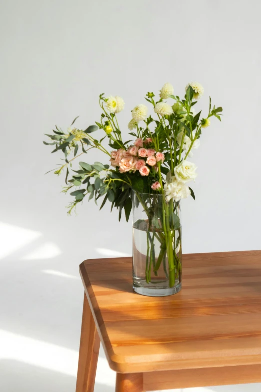 a vase of flowers sitting on top of a wooden table, by Jessie Algie, designed for cozy aesthetics!, delicate, with a soft, entertaining