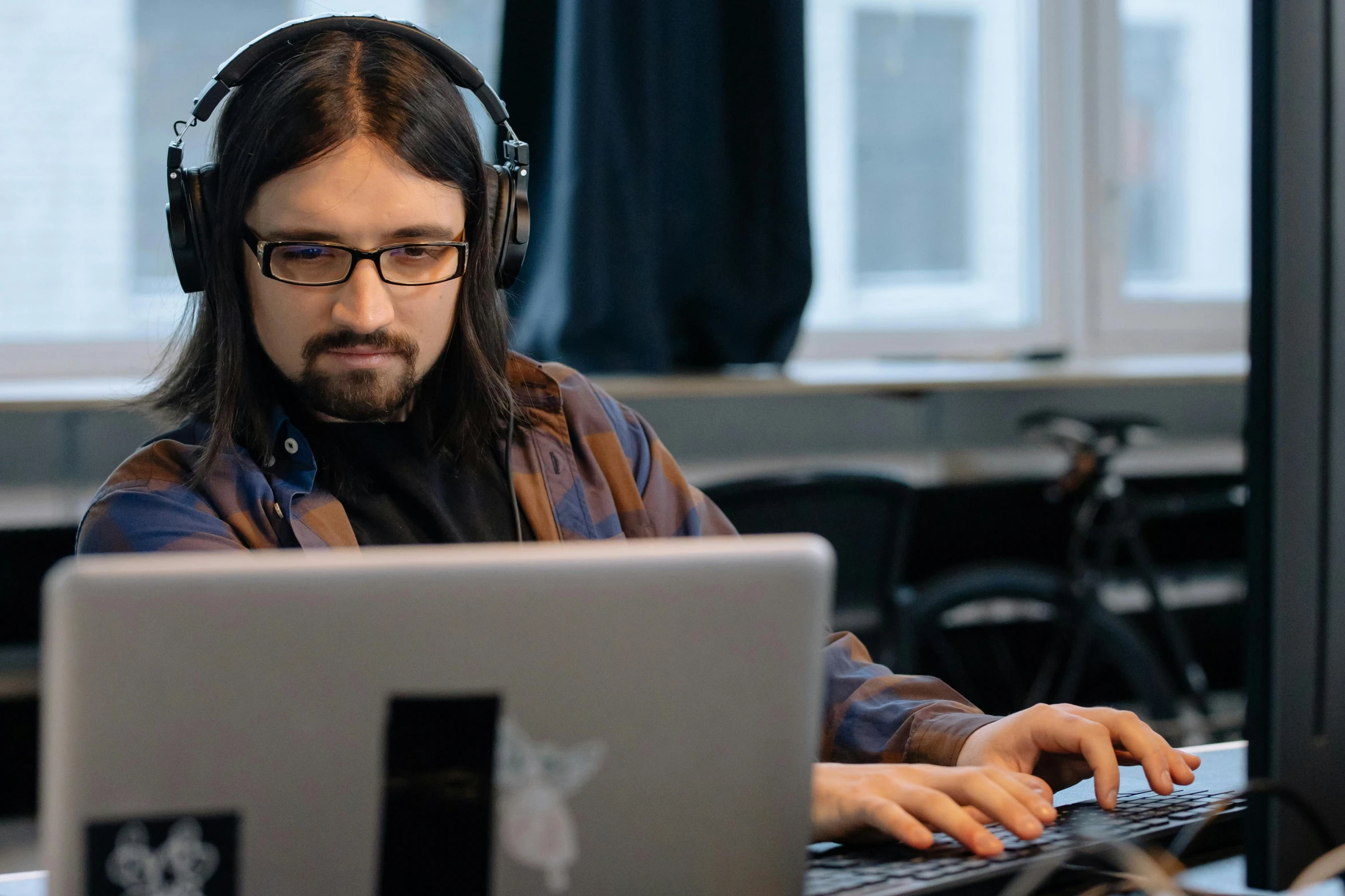 a man sitting in front of a computer wearing headphones, by Eero Järnefelt, reddit, ricky berwick, johnny silverhand, typing on laptop, mid shot photo