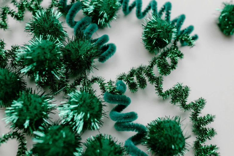 a bunch of green tinsels sitting on top of a table, monochromatic teal, spiralling, detailed product image, detail shot